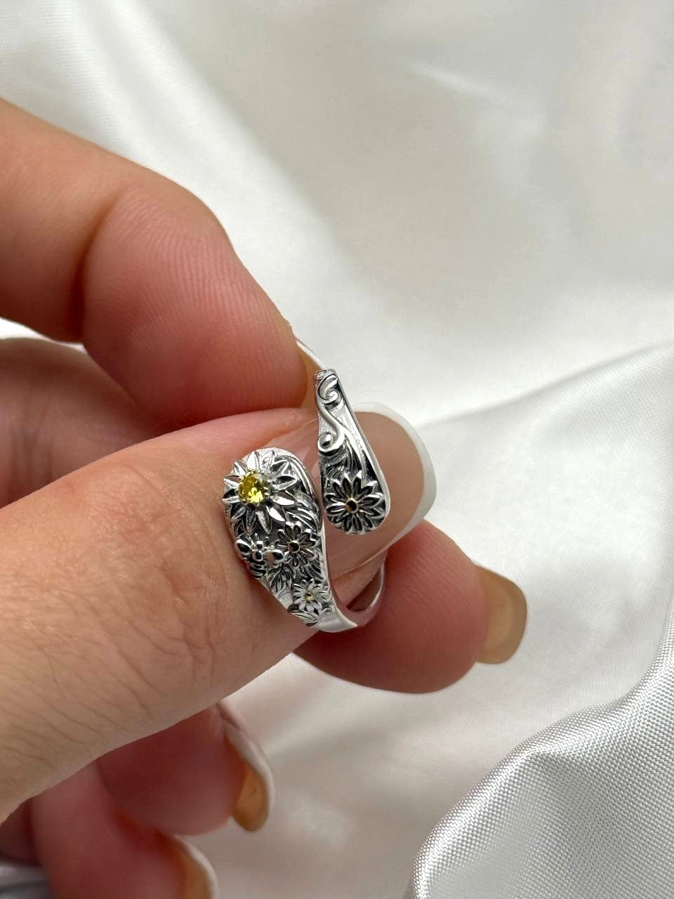 Close-up of adjustable sterling silver floral ring with yellow zircon and detailed botanical motifs