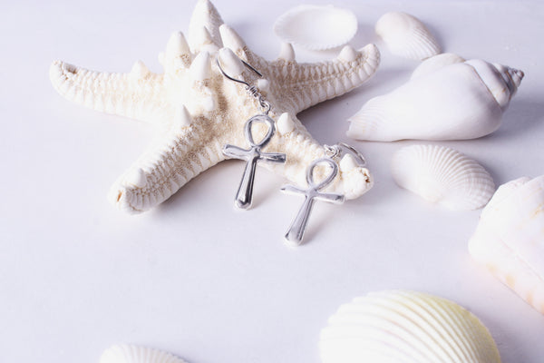 Sterling silver Ankh symbol earrings styled with seashells