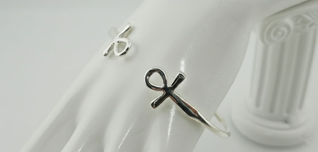 “925 sterling silver Ankh cuff bracelet displayed on white fabric with sculpted details visible”