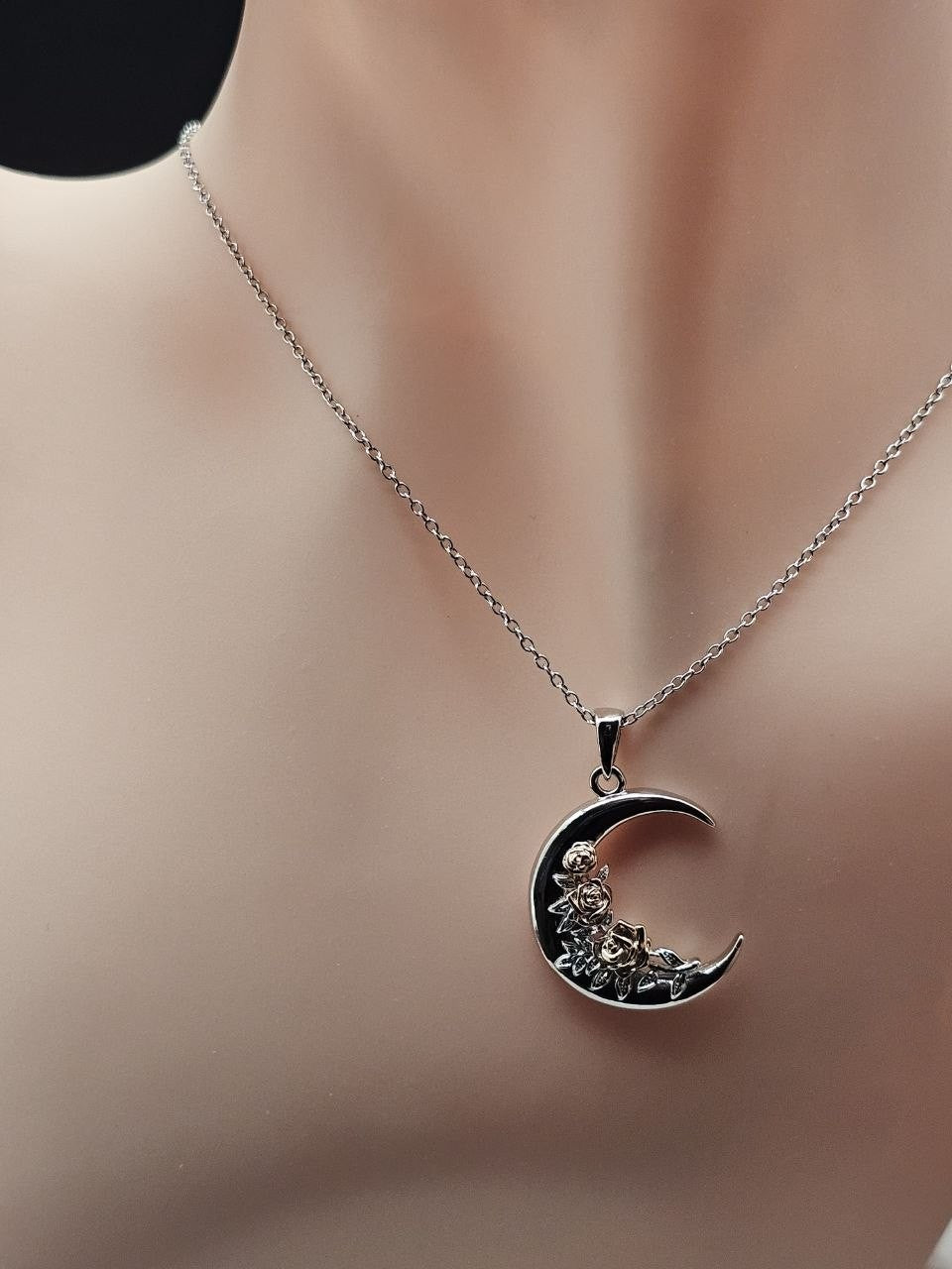 Crescent moon rose 925 sterling silver necklace displayed on a jewelry bust.