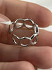 Close-up of an adjustable sterling silver ring with flowing open circle design