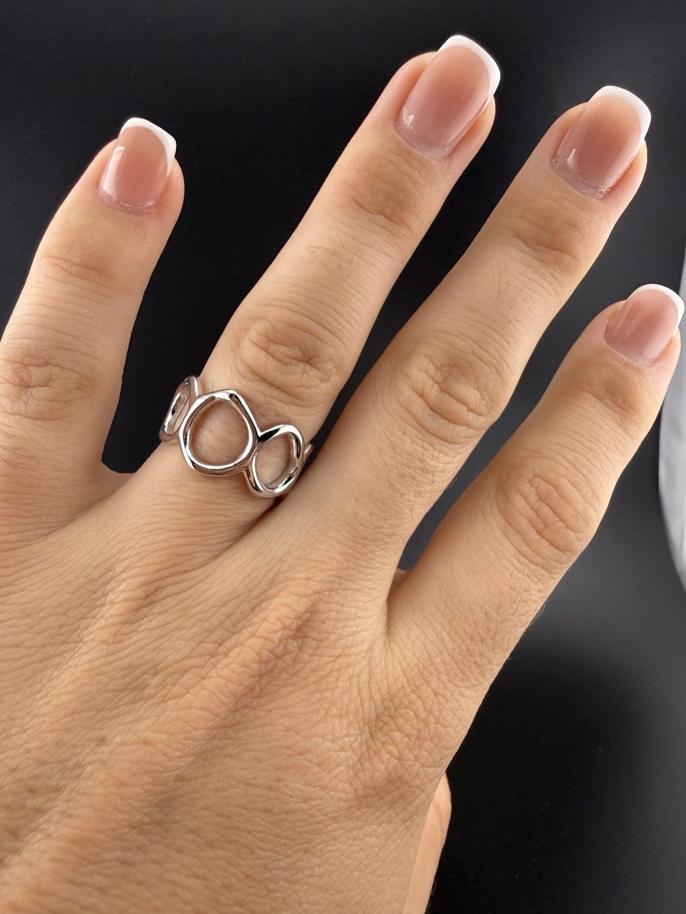Adjustable sterling silver open circle ring shown on hand for scale and fit