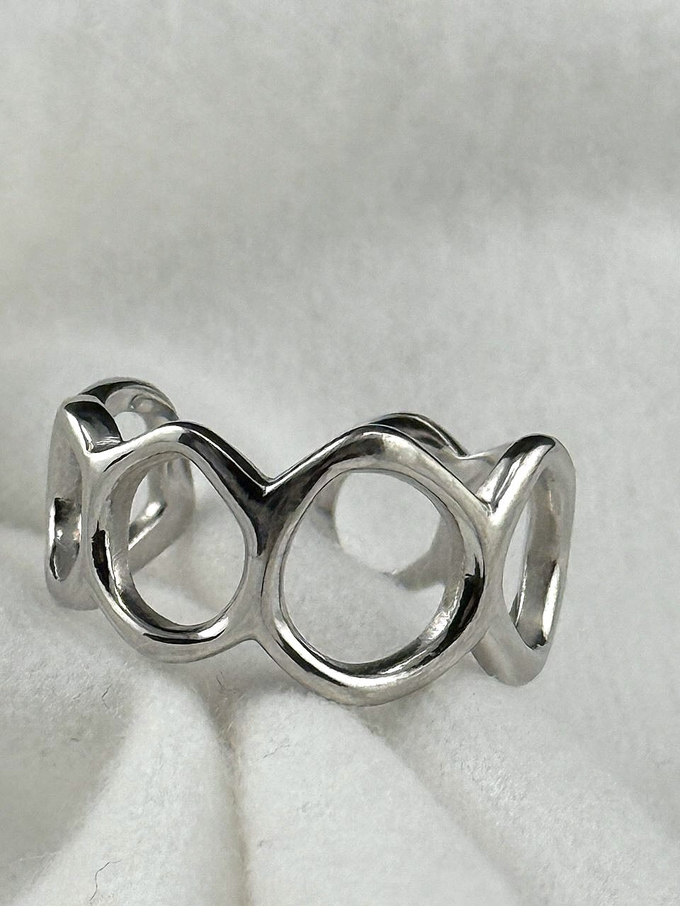 Close-up of Flowing Circle adjustable sterling silver ring showing polished openwork details