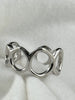 Close-up of Flowing Circle adjustable sterling silver ring showing polished openwork details