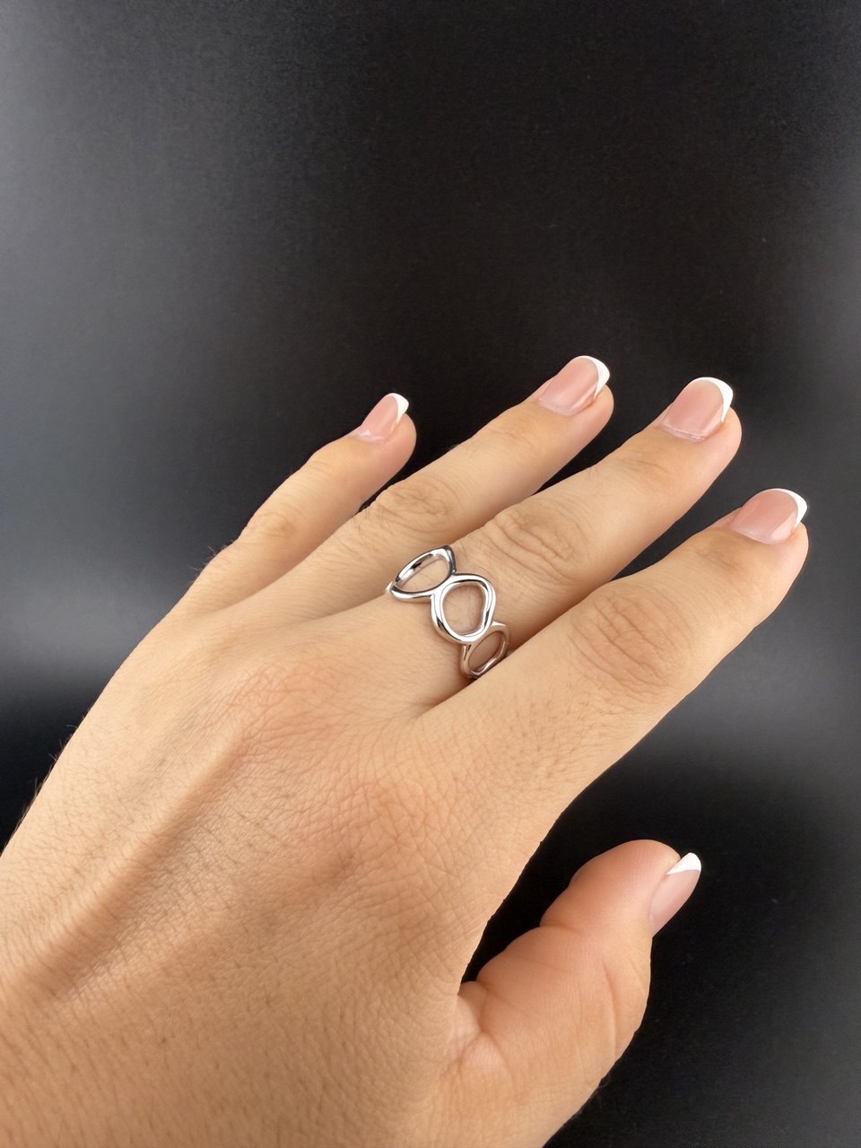 Sterling silver flowing circle ring worn on hand, showing its openwork design and adjustable fit