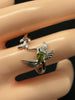Close-up of a 925 sterling silver hummingbird ring with a pear-shaped green zircon and detailed wings.