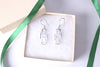 Sterling silver Gye Nyame Adinkra symbol earrings displayed in a gift box