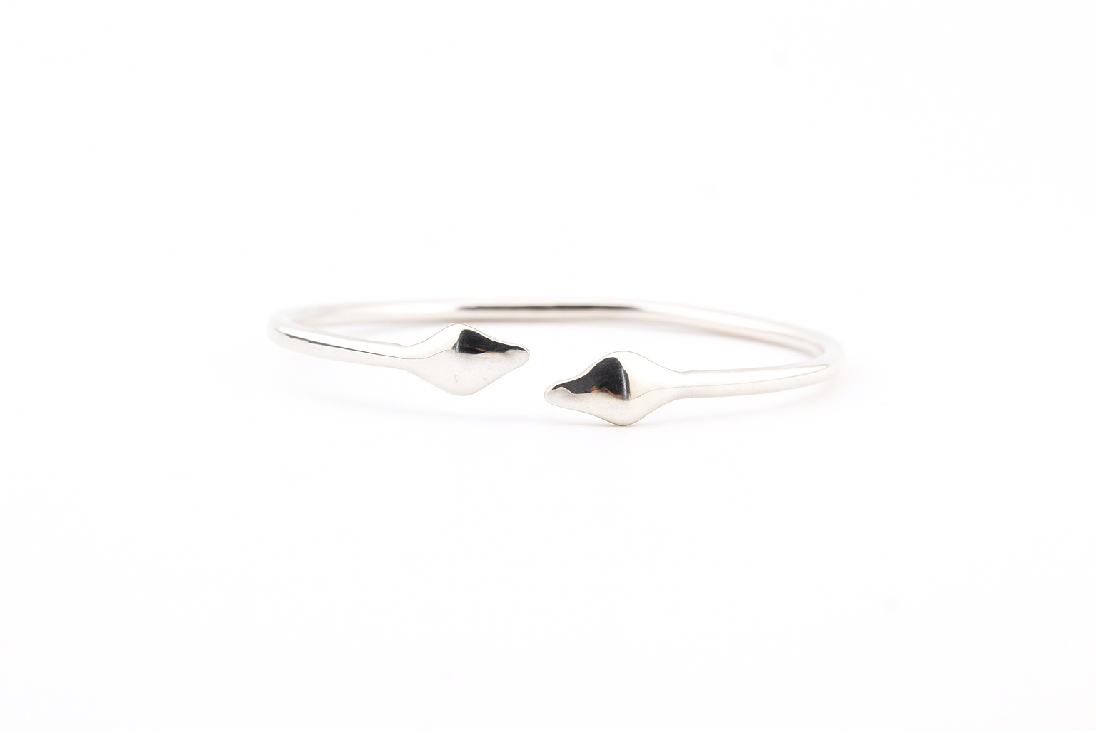 "Top view of a silver twin cobra cuff bracelet with two snake heads on a white background."