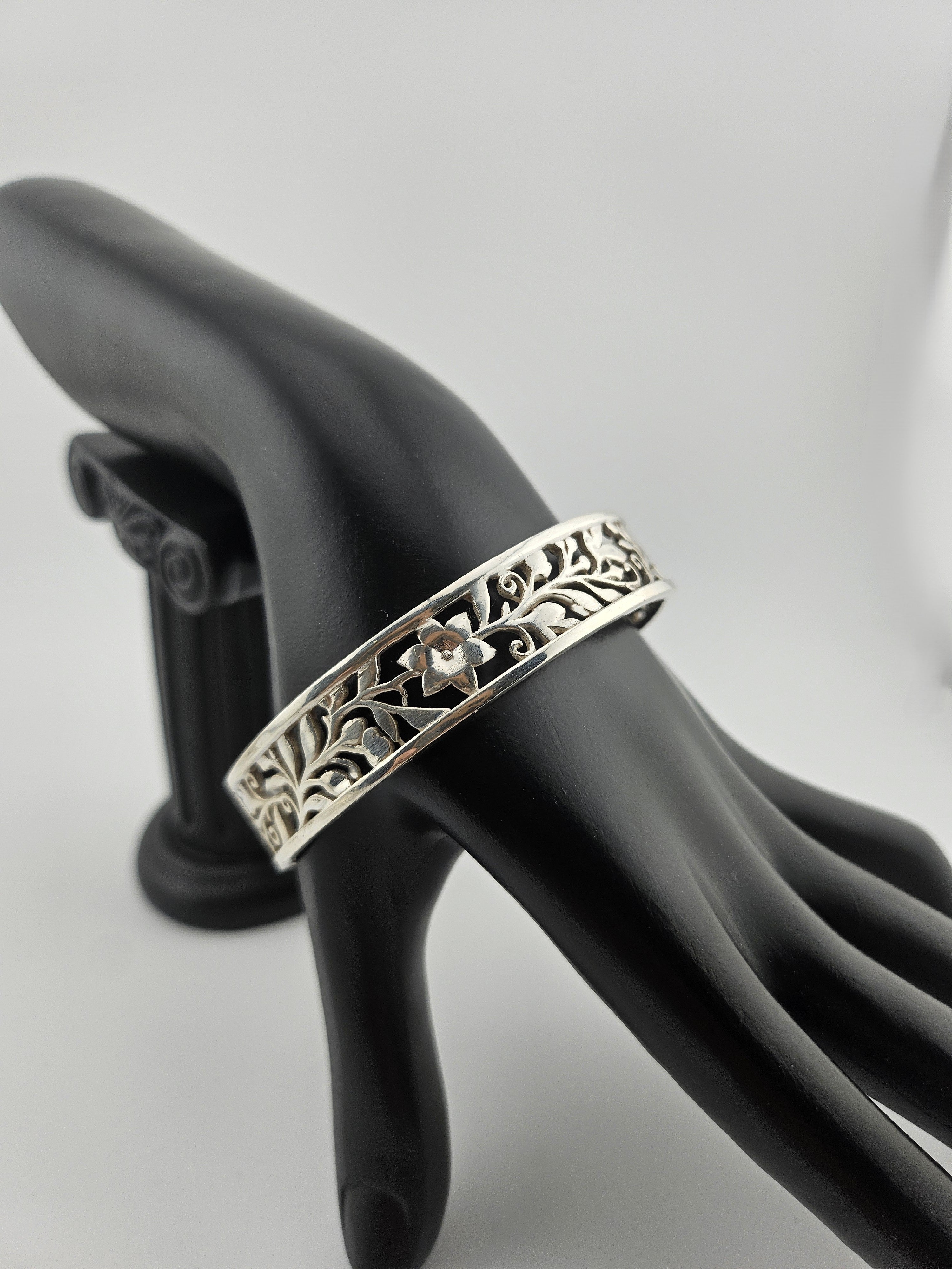 "Sterling silver floral vine cuff bracelet on black mannequin hand"