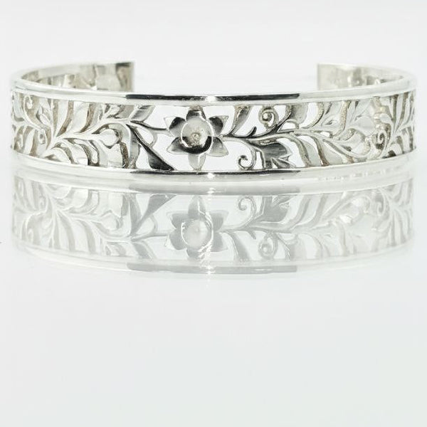 "Close-up sterling silver floral vine cuff bracelet with detailed engraved pattern"