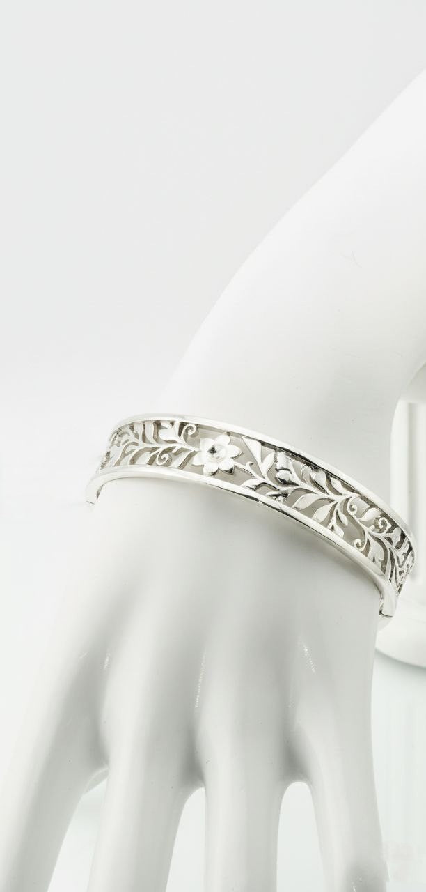 "Sterling silver floral vine cuff bracelet on mannequin hand — detailed openwork leaf engraving luxury silver jewelry"
