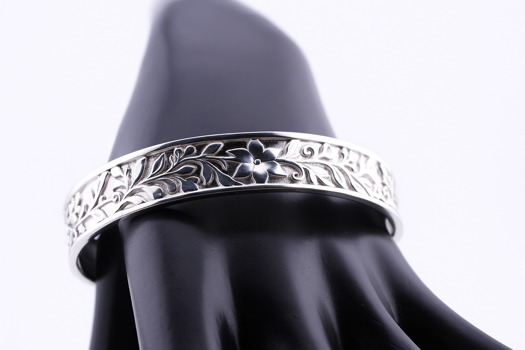 "Royal silver cuff bracelet with floral flower engraving displayed on a black mannequin hand — luxury sterling silver jewelry by Lakseena."