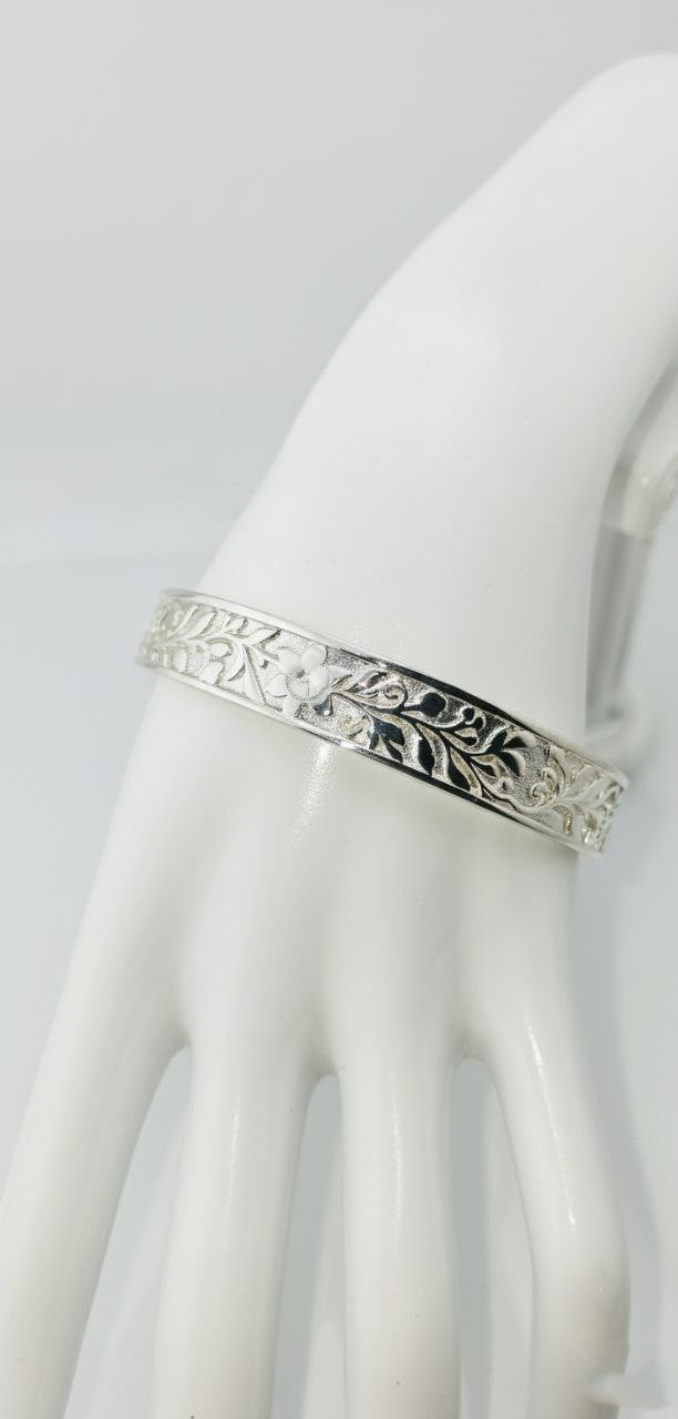 "Royal silver cuff bracelet with floral flower and leaf design shown on a white mannequin hand against a clean white background — luxury sterling silver jewelry."