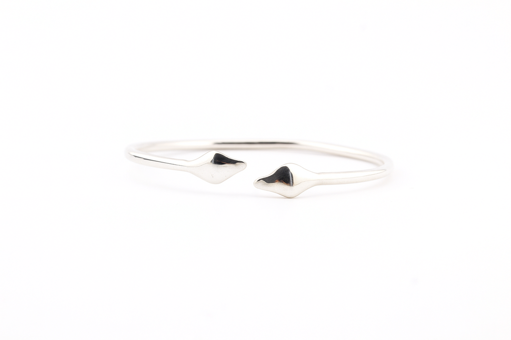 "Top view of a 925 sterling silver cuff bracelet with twin sculpted serpentine design on a white background."

