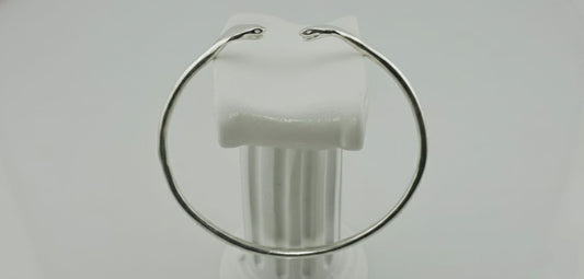 "Side view of a silver twin cobra cuff bracelet with two sculpted snake heads on a white background."