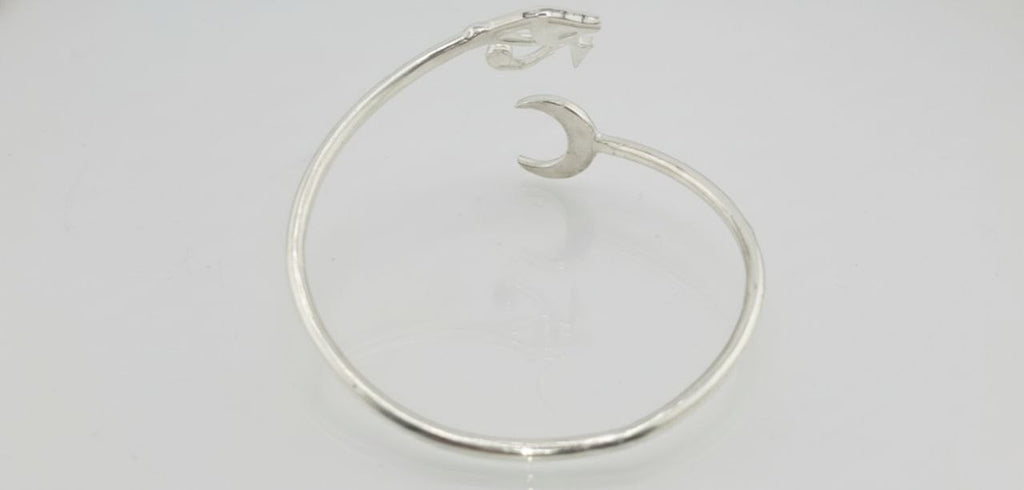 back view of a sterling silver cuff bracelet with engraved eye and crescent moon detail