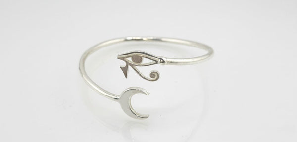 sterling silver cuff bracelet with engraved eye and crescent moon design, photographed on a light background
