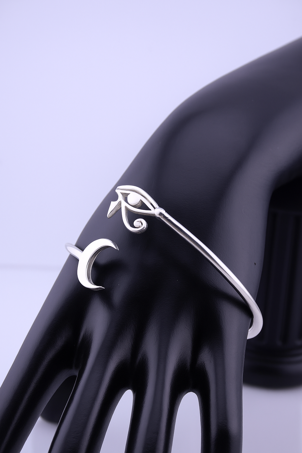 “Sterling silver Horus eye cuff bracelet with crescent moon — shown on black display hand.”