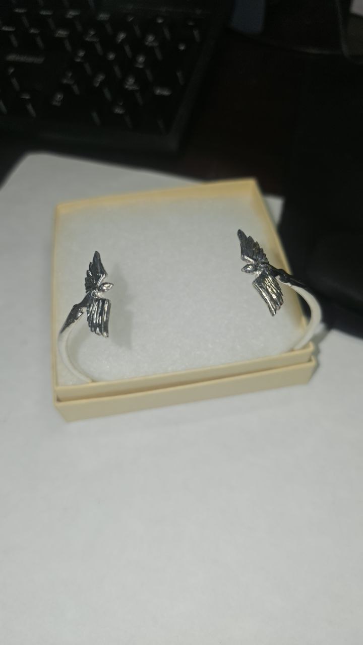 Authentic photo of the Twin Wings sterling silver bracelet in its presentation box. Clear view of the 925 silver shine and intricate bird design. Handmade jewelry by Lakseena.