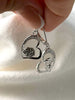 Close-up of sterling silver heart earrings with rose and masquerade mask details and cubic zirconia accents