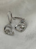 Close-up of sterling silver heart earrings with rose and masquerade mask details and cubic zirconia accents