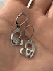 Sterling silver rose and masquerade heart earrings with cubic zirconia accents shown in hand for scale