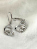 Front view of sterling silver heart earrings featuring a rose and masquerade mask with sparkling stone accents