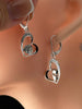 Rose and masquerade heart sterling silver earrings shown on ear with sparkling stone accents