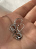Sterling silver rose and masquerade heart earrings with cubic zirconia accents shown in hand