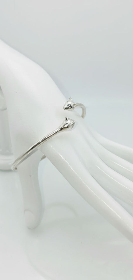 “Silver Cat Bracelet – vertical close-up of 925 sterling silver open cuff with twin cat heads on a white mannequin hand”