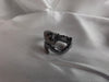 Oxidized sterling silver dragon ring with hand-polished finish on white satin.