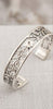 Handcrafted 925 sterling silver cuff bracelet with intricate floral patterns, heritage jewelry style.

