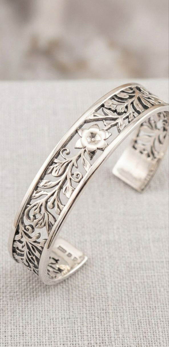 Handcrafted 925 sterling silver cuff bracelet with intricate floral patterns, heritage jewelry style.

