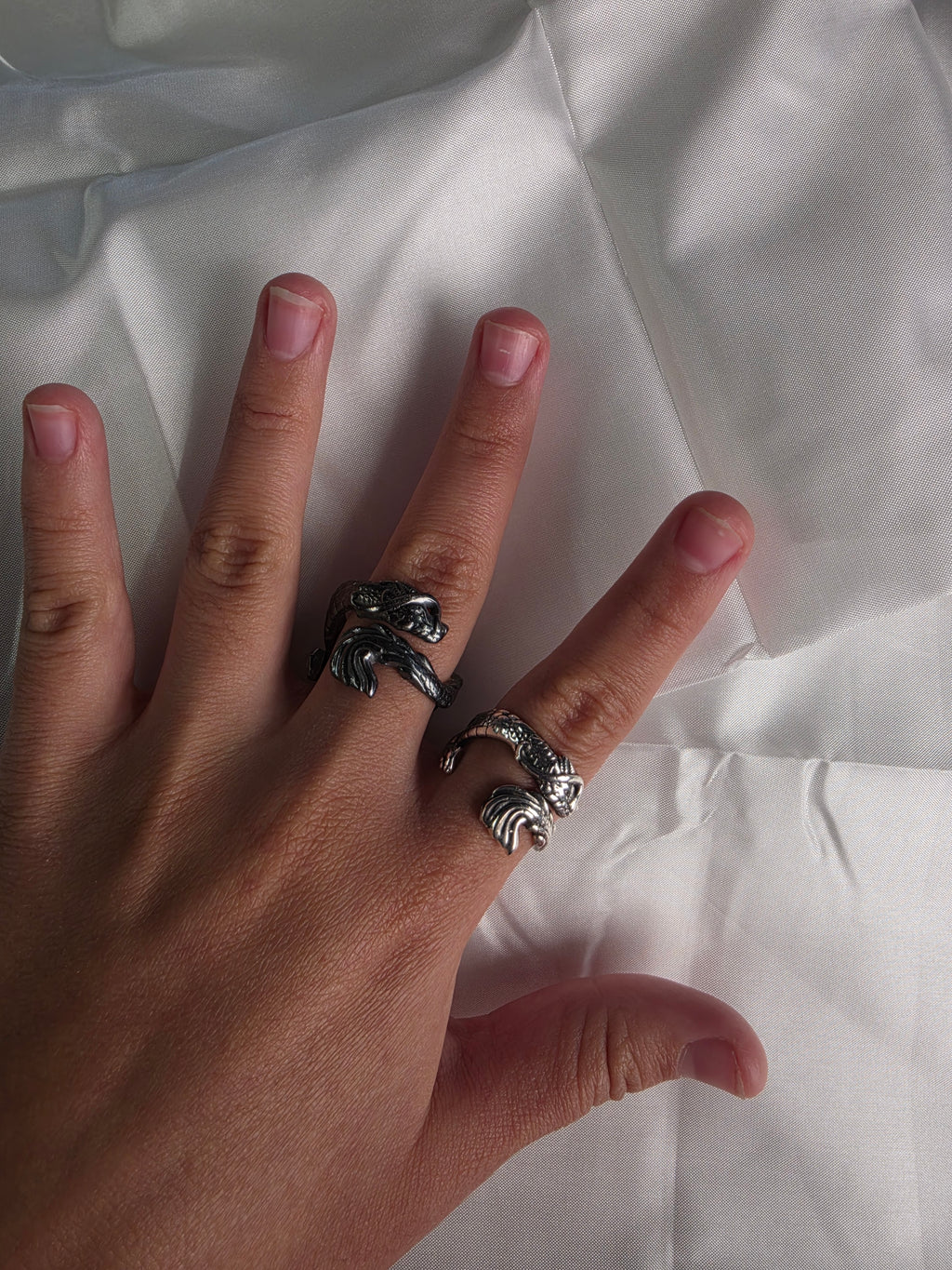 Two handcrafted 925 sterling silver dragon rings worn on a hand to show scale and detail.