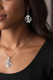 Handcrafted sterling silver symbol dangle earrings worn by a model, highlighting scale and elegant everyday style
