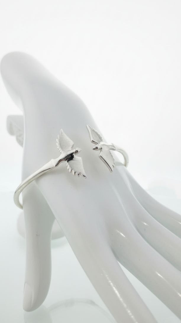 "925 sterling silver cuff bracelet with twin wings of freedom design displayed on hand model"