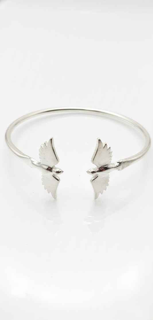 "top view of 925 sterling silver cuff bracelet with twin wings of freedom design on white background"