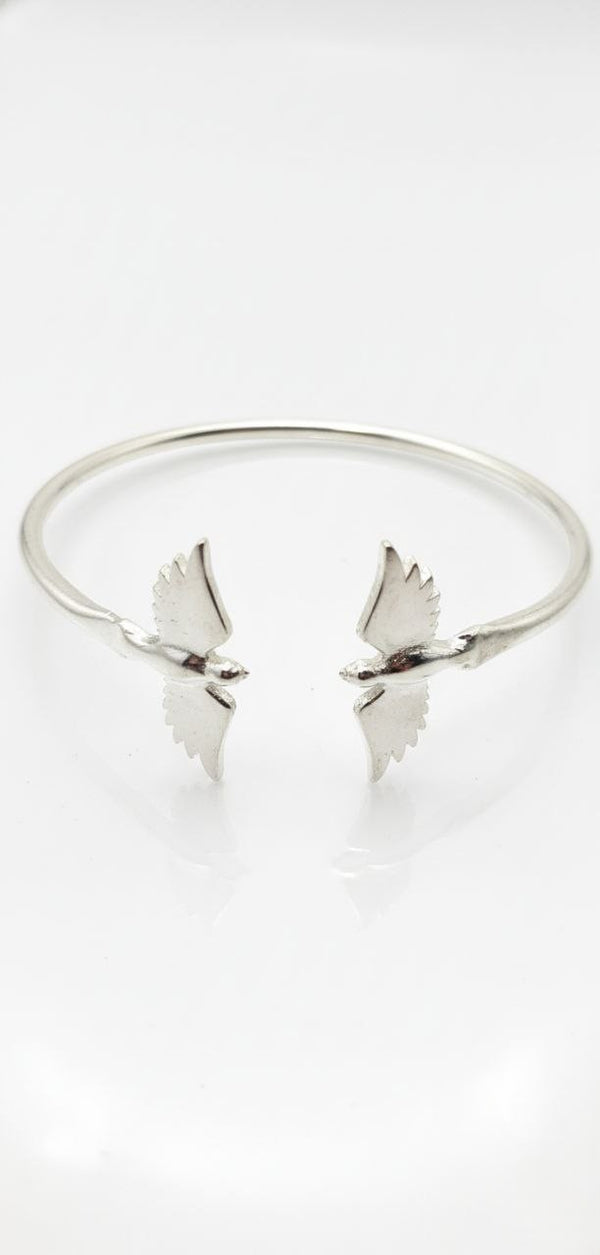 top view of 925 sterling silver cuff bracelet with twin bird-wing design on white background